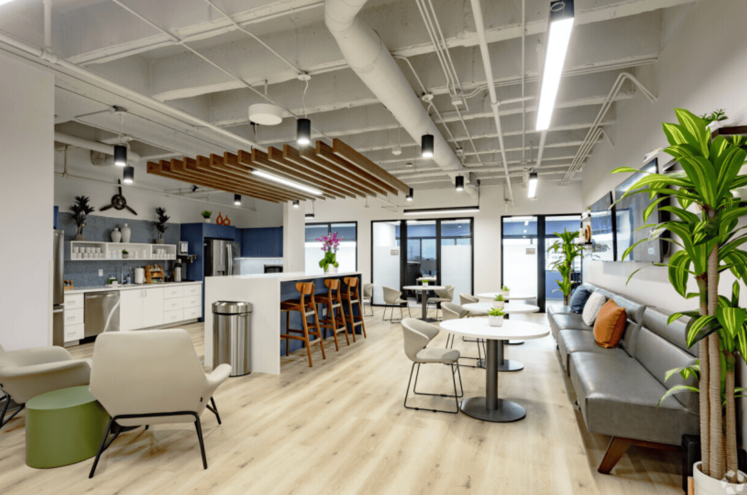 Modern coworking space at Vast Coworking with bright lighting, comfortable seating, and vibrant greenery, ideal for remote work, meetings, and networking in a professional environment.
