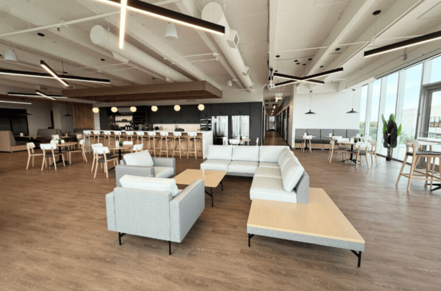 Modern coworking space at Vast Coworking with open seating, comfortable lounge areas, and large windows providing natural light, ideal for remote work and collaboration.