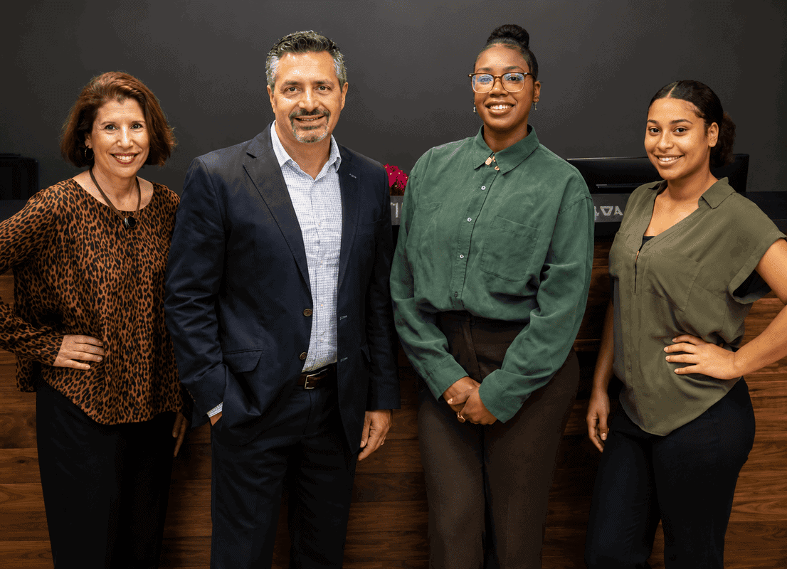 Diverse group of four professionals standing together in a coworking space at Vast Coworking.