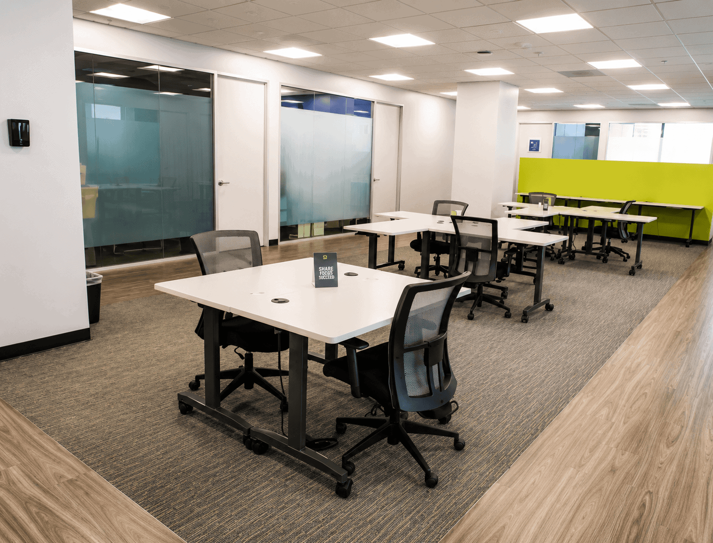 Spacious coworking area with desks, chairs, and a bright, open layout at Vast Coworking.