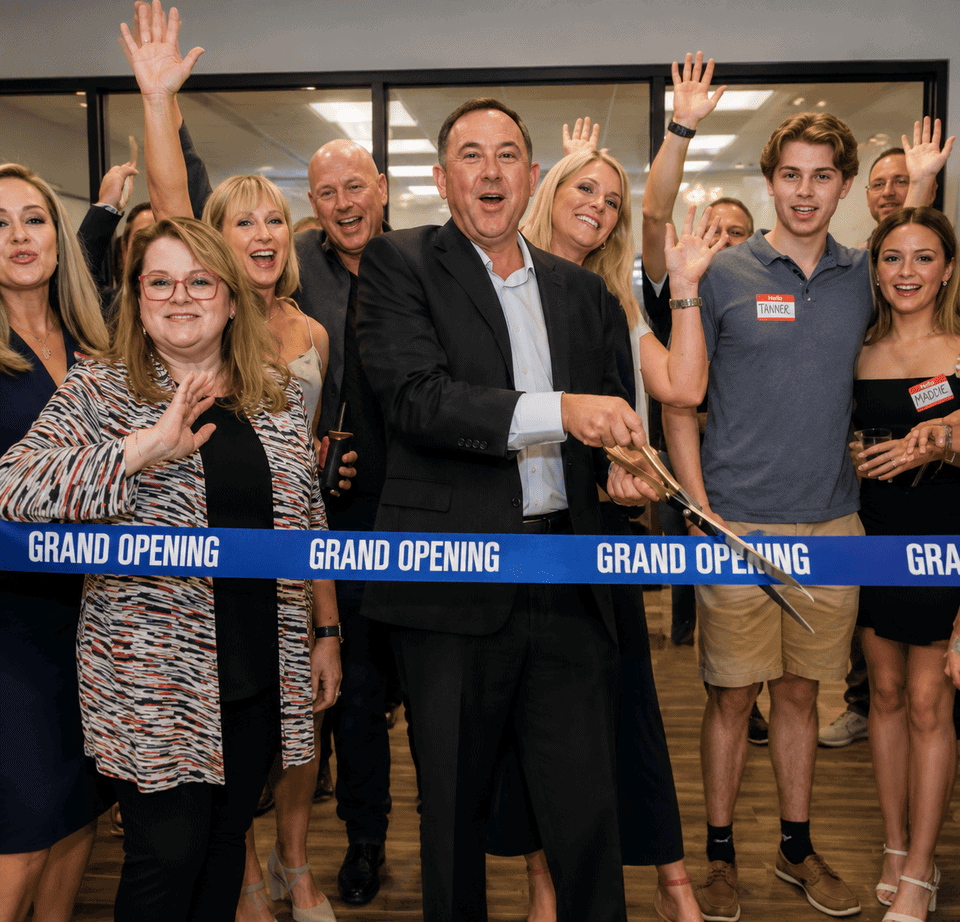 Group of diverse people celebrating grand opening at Vast Coworking with ribbon cutting ceremony.