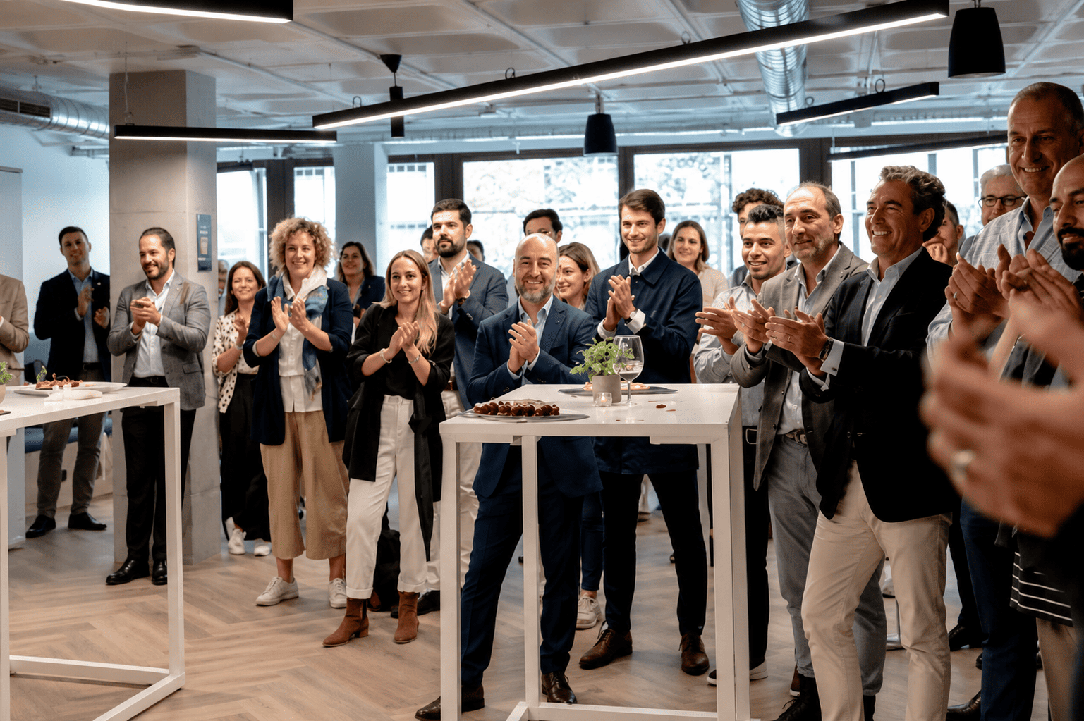 Group of diverse professionals celebrating at a coworking space during a corporate event.