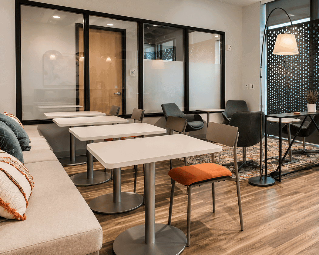 Modern coworking space with tables, chairs, and a cozy lounge area at Vast Coworking.